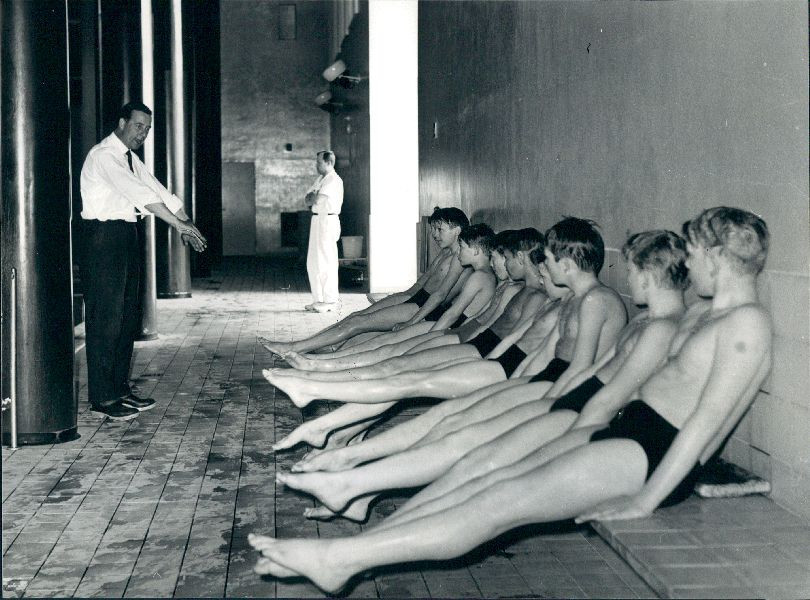 Svømmelærer Erik Balle instruerer en skoleklasse i svømning. 1964. Foto: Erik Olsen. Frederiksberg Stadsarkiv.